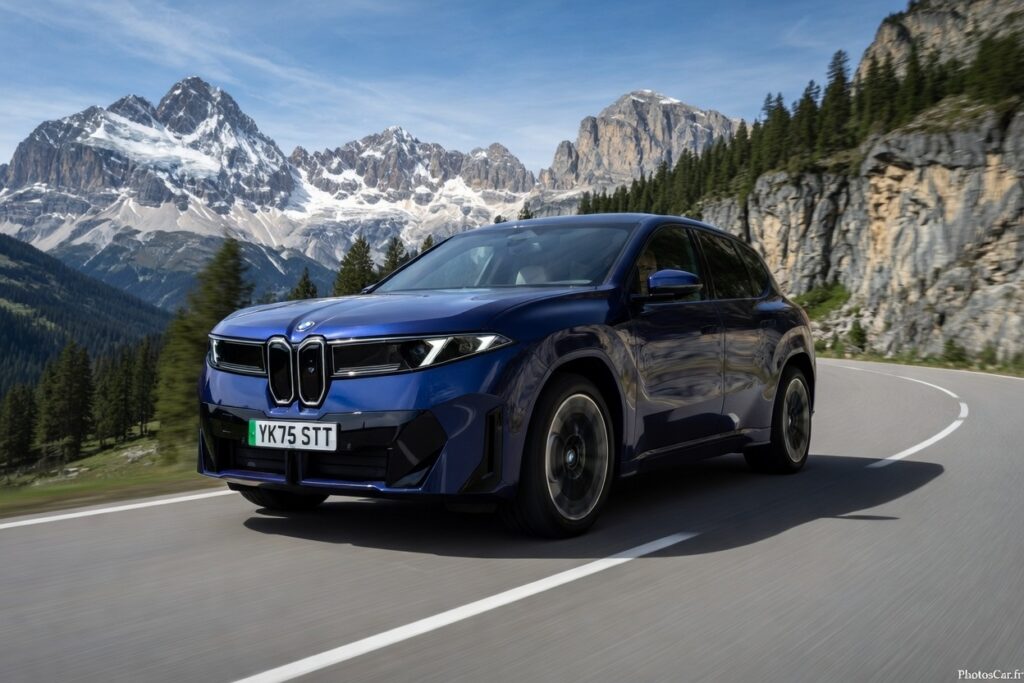 Le puissant iX3 50 xDrive 100% électrique sur une route de montagne ensoleillée.